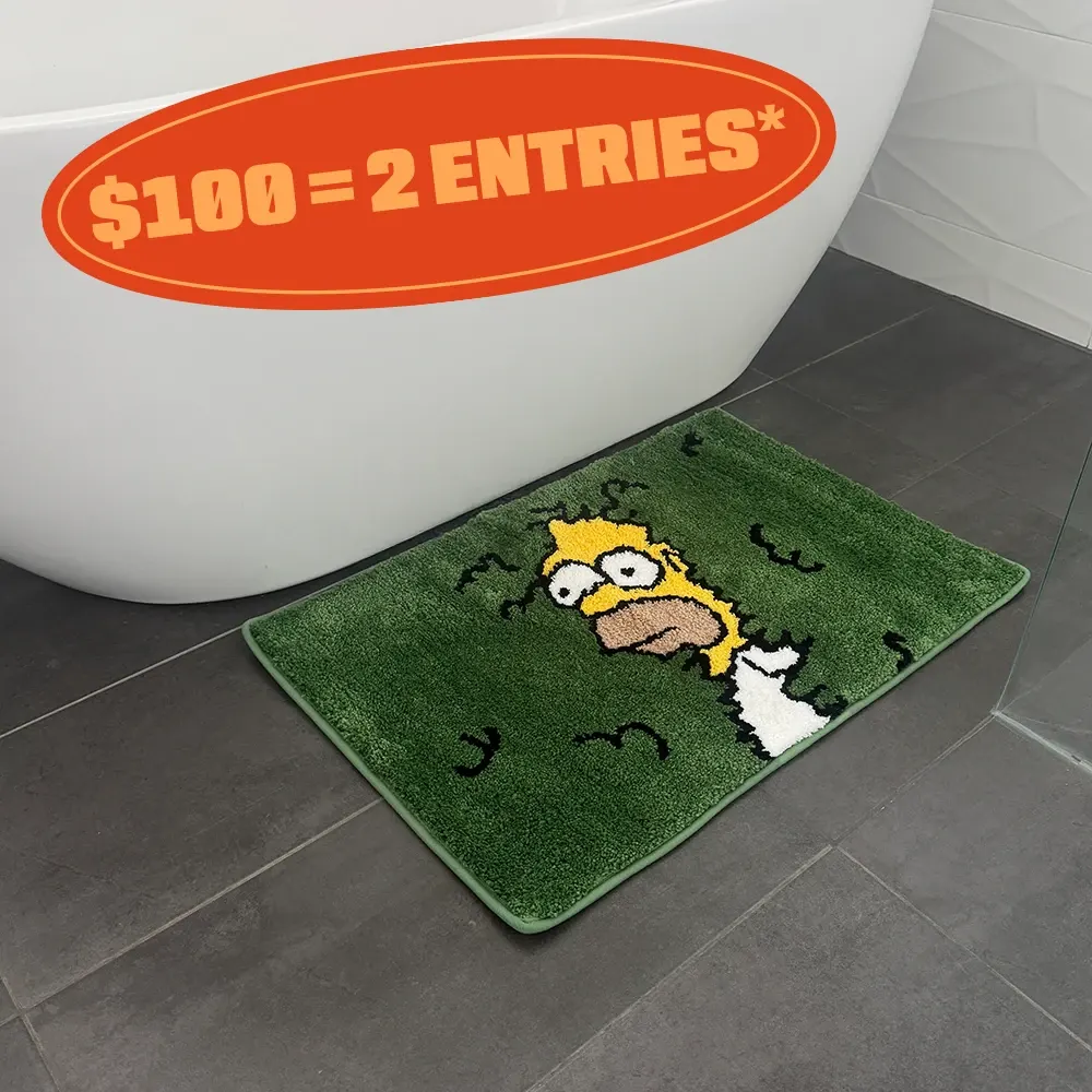 Funny cartoon bath mat with Homer Simpson design placed beside a white bathtub